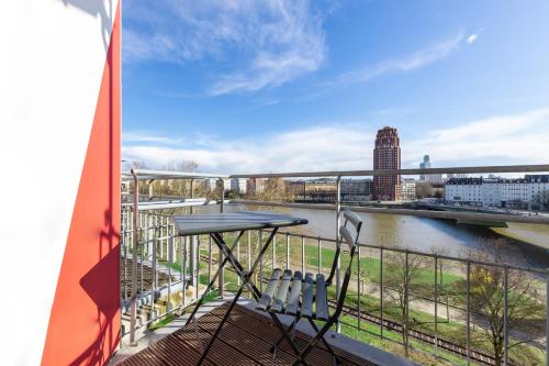 a balcony with a table and chairs overlooking a river at Trip Inn Residence City Center in Frankfurt/Main