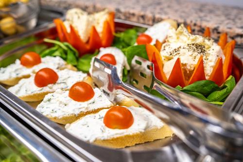 a tray of food with bread with tomatoes and vegetables at New Era Hotel Old Town Bucharest- parking with fee nearby - NOT at the hotel ! in Bucharest
