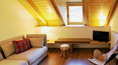 a living room with a couch and a table with a tv at Hotel Lo Paller in Valencia de Aneu