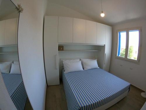 a small bedroom with two beds and a window at Villino Blu Mare in San Teodoro