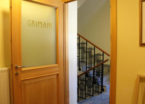 a glass door with a sign that reads grimnant at Residenza d'Epoca Albergo Grimani in Ampezzo