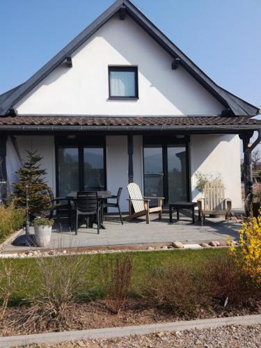 a house with a table and chairs on a porch at Le Clos du Haslach in Niederhaslach