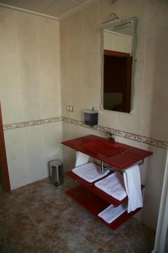 a bathroom with a red sink and a mirror at HOSTAL EL POLIGONO in La Roda
