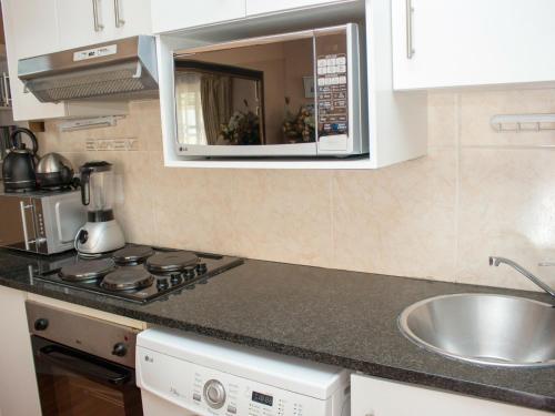 a kitchen with a sink and a microwave at Onyx on Sycamore in Cape Town