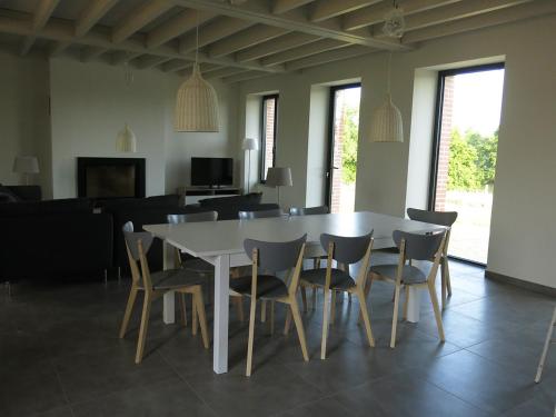 ein Esszimmer mit einem weißen Tisch und Stühlen in der Unterkunft Gîte familial à l'Aiguillon-sur-Vie in LʼAiguillon-sur-Vie