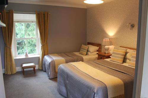 Habitación de hotel con 2 camas y ventana en Grey Gables Farmhouse B&B en Inishannon