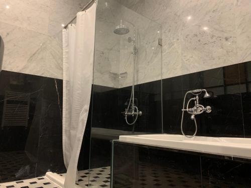 a bathroom with a shower and a bath tub at El Boutique Hotel in Soûr