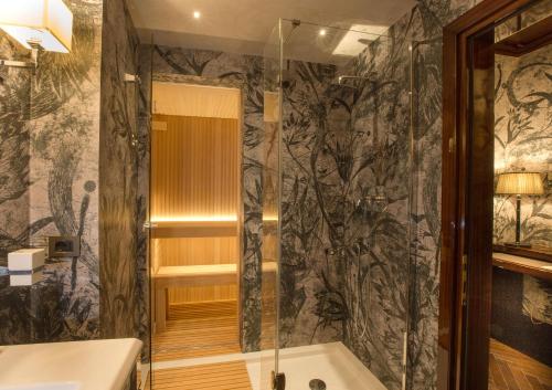 a bathroom with a shower and a tub at Grand Hotel Baglioni in Florence