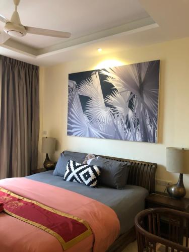 a bedroom with a bed with a painting on the wall at Blue Chang House in Bangkok