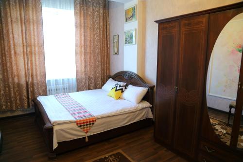 Un dormitorio pequeño con una cama y una ventana. en Comfort Apartment, en Bishkek