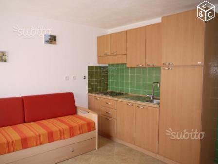 une cuisine avec un canapé rouge et un évier dans l'établissement Les jardins de la mer, à Linguizzetta