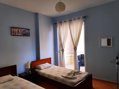 sypialnia z 2 łóżkami i oknem w obiekcie Apartment Angel w Sarandzie