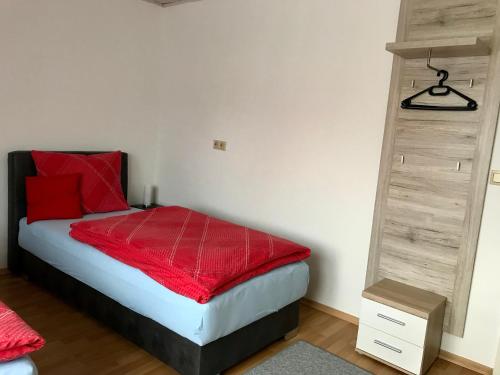 a bedroom with a bed with a red blanket on it at JUNA in Karlsruhe