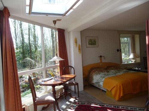 a bedroom with a bed and a table and a window at Selatuinen in Appelscha