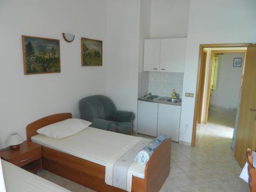 1 dormitorio pequeño con 1 cama y cocina en Winery Bačić, en Blato