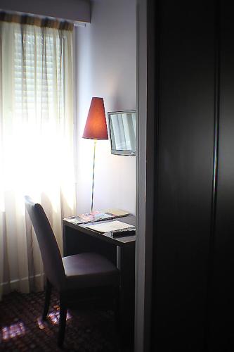 a desk with a lamp and a chair next to a window at Le Ceïtya in Saint-Gilles-Croix-de-Vie