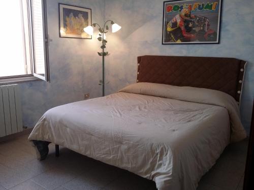 Un dormitorio con una cama y una lámpara. en Su Matutzu, en San Giovanni Suergiu