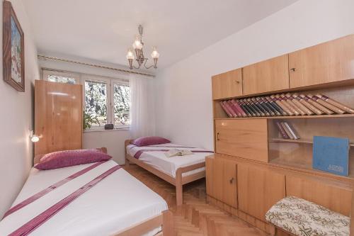 a bedroom with two beds and a dresser at Apartment Nansy in Omiš