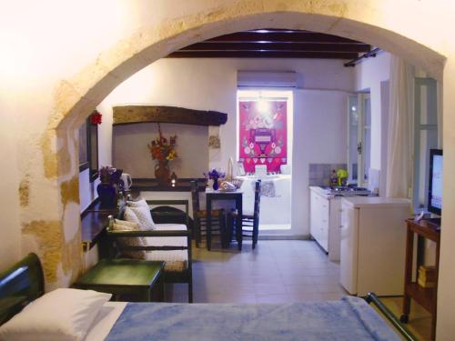 a kitchen and a living room with an archway at Madonna Studios in Chania