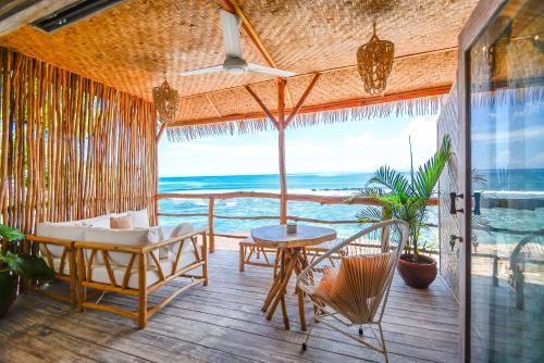 a room with a balcony with a view of the ocean at Le Cliff Bali in Uluwatu