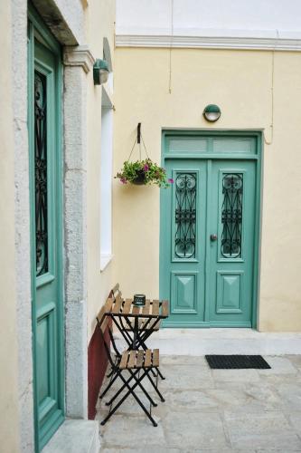 a green door and a table next to a building at SeaMe Houses in Symi