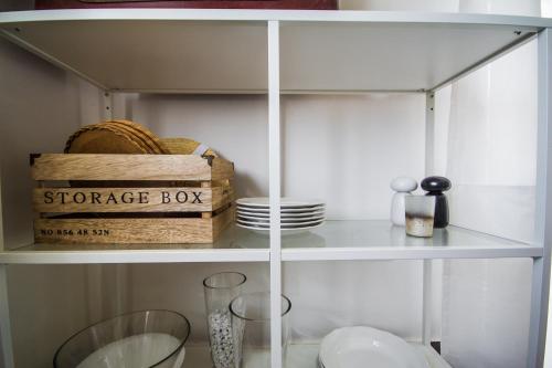 a white shelf with a storage box and plates at Villa Mamma Mia Oprtalj in Oprtalj