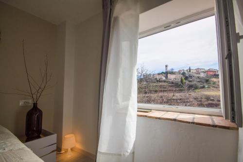 a bedroom with a window with a white curtain at Villa Mamma Mia Oprtalj in Oprtalj