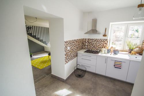 a kitchen with white cabinets and a sink and a staircase at Villa Mamma Mia Oprtalj in Oprtalj