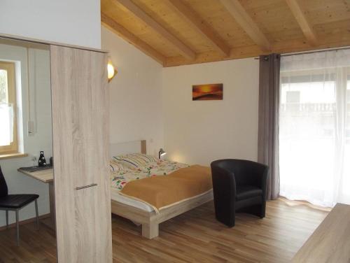 a bedroom with a bed and a desk and a chair at Gästehaus Hubertus Bad Aibling in Bad Aibling