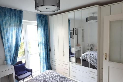 una camera da letto con specchio, letto e finestra di ruhige Ferienwohnung mitten in Wiesbaden a Wiesbaden