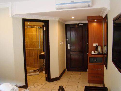 a room with a door and a bathroom with a shower at Zawadi House Lodge in Arusha