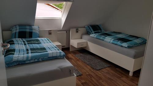 a small bedroom with two beds and a window at Ferienwohnung in Freimersheim