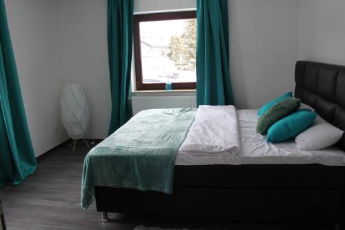 a bedroom with a bed with green curtains and a window at FeWo Topas Balingen in Balingen