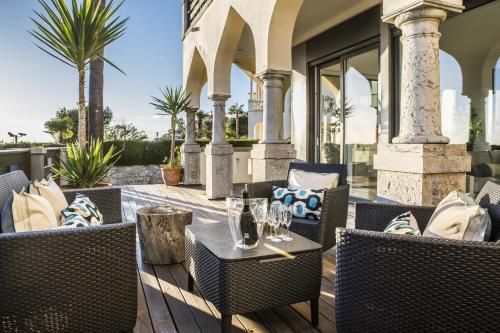 a patio with chairs and tables on a porch at The Seafront Manor by The Getaway Collection in Cascais