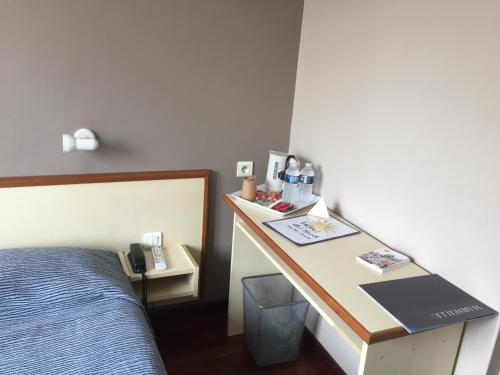 - une chambre avec un lit et un bureau dans l'établissement Hôtel du Sud Vieux Port, à Marseille