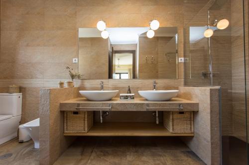 a bathroom with two sinks and a large mirror at La Casona del Torcon in Navahermosa