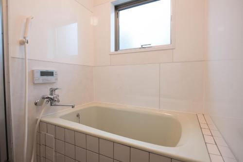 a bath tub in a bathroom with a window at グローバルリゾート宮島 天神ハウス in Miyajima