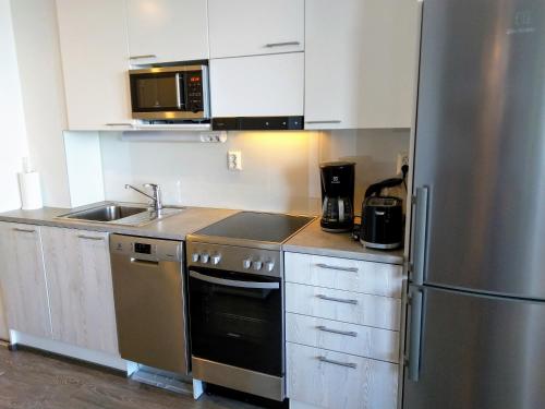 een keuken met een roestvrijstalen koelkast en een wastafel bij Pro Apartments 4 in Vaasa