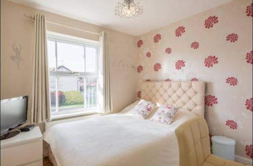 a bedroom with a white bed and a window at Comfy private room in shared house in Cambridge