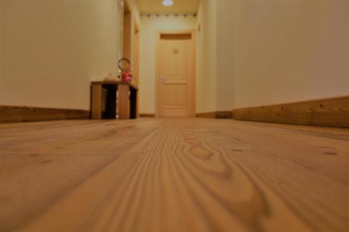 an empty room with a wooden floor and a door at Residenza d'Epoca Albergo Grimani in Ampezzo