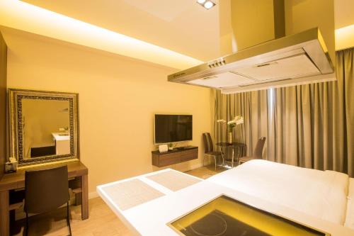 a bedroom with a bed and a mirror and a desk at Accra Fine Suites - The Pearl In City in Accra