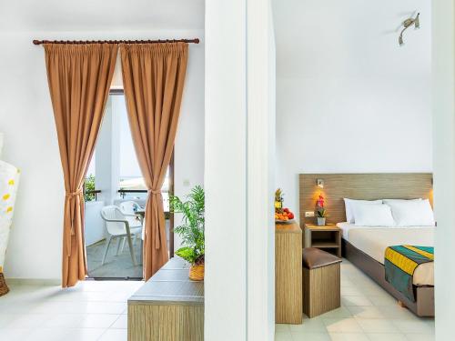 a hotel room with a bed and a dining room at Xenios Dolphin Beach Hotel in Possidi