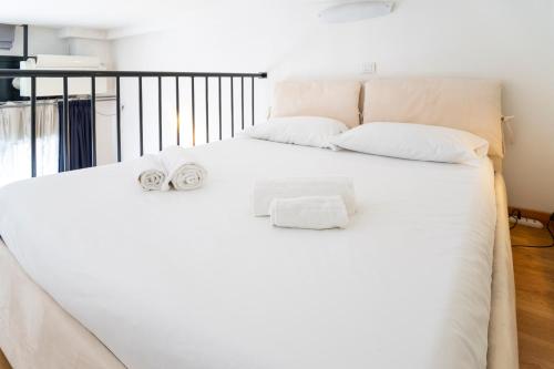 a bedroom with a white bed with towels on it at PrimoPiano - Inama in Milan