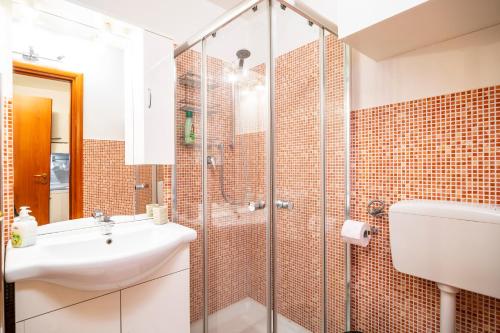 a bathroom with a glass shower and a sink at PrimoPiano - Inama in Milan