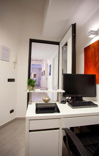 a desk with a computer on it with a mirror at Elements Guest House in Rome