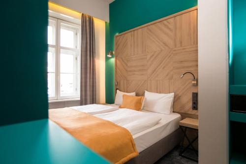 a bedroom with a bed with a green wall at T62 Hotel in Budapest