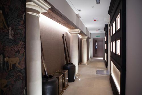 a hallway with columns and vases in a building at Palacete Colonial in León