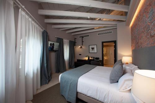a bedroom with a white bed and a desk in it at Palacete Colonial in León