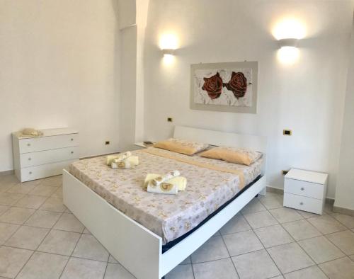 a bedroom with a large white bed in a room at Villetta Natalia in Torre Colimena