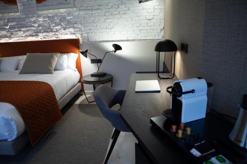 a hotel room with a bed and a desk with a laptop at Palacete Colonial in León